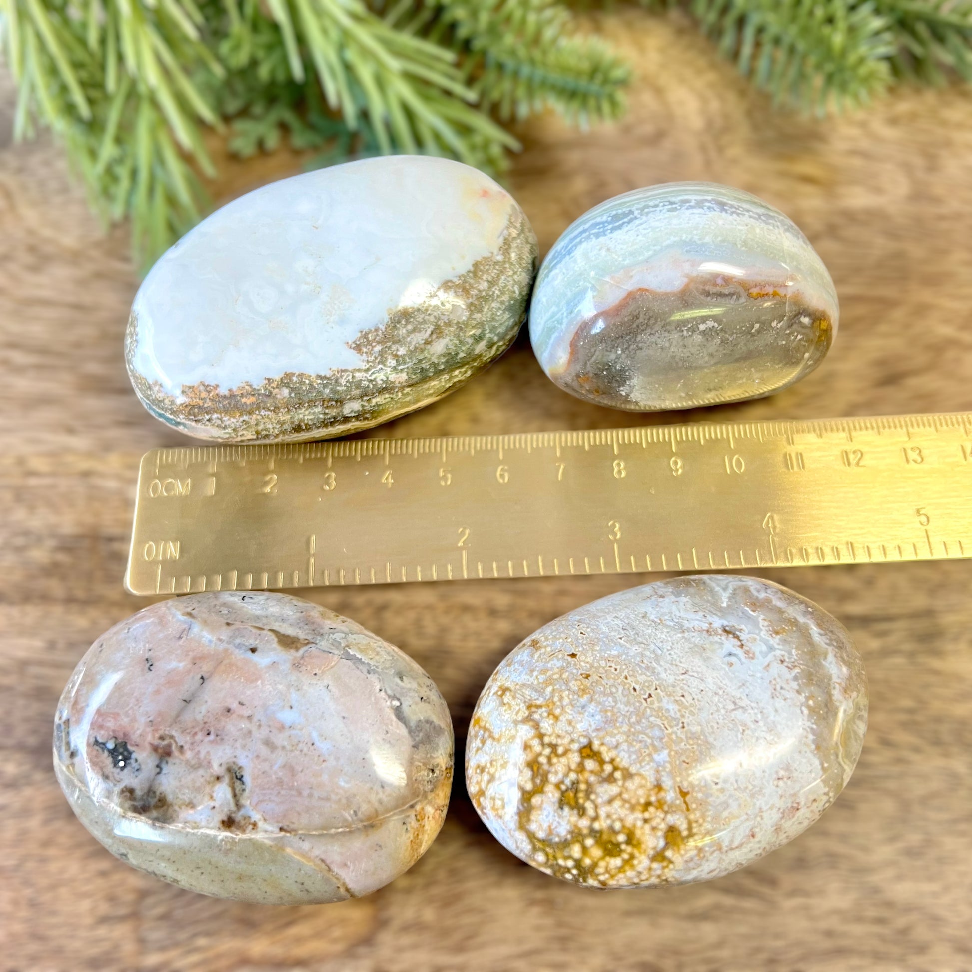 a wooden table topped with three rocks next to a ruler