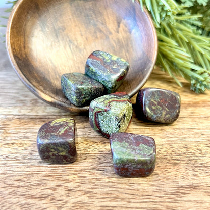 Group of green and red tumbled crystals. They are Dragon Blood Stone, and a polished cube shape.