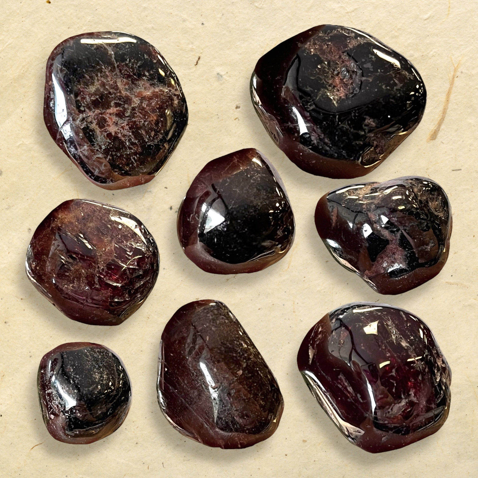 A collage of very dark red garnet tumbled crystals