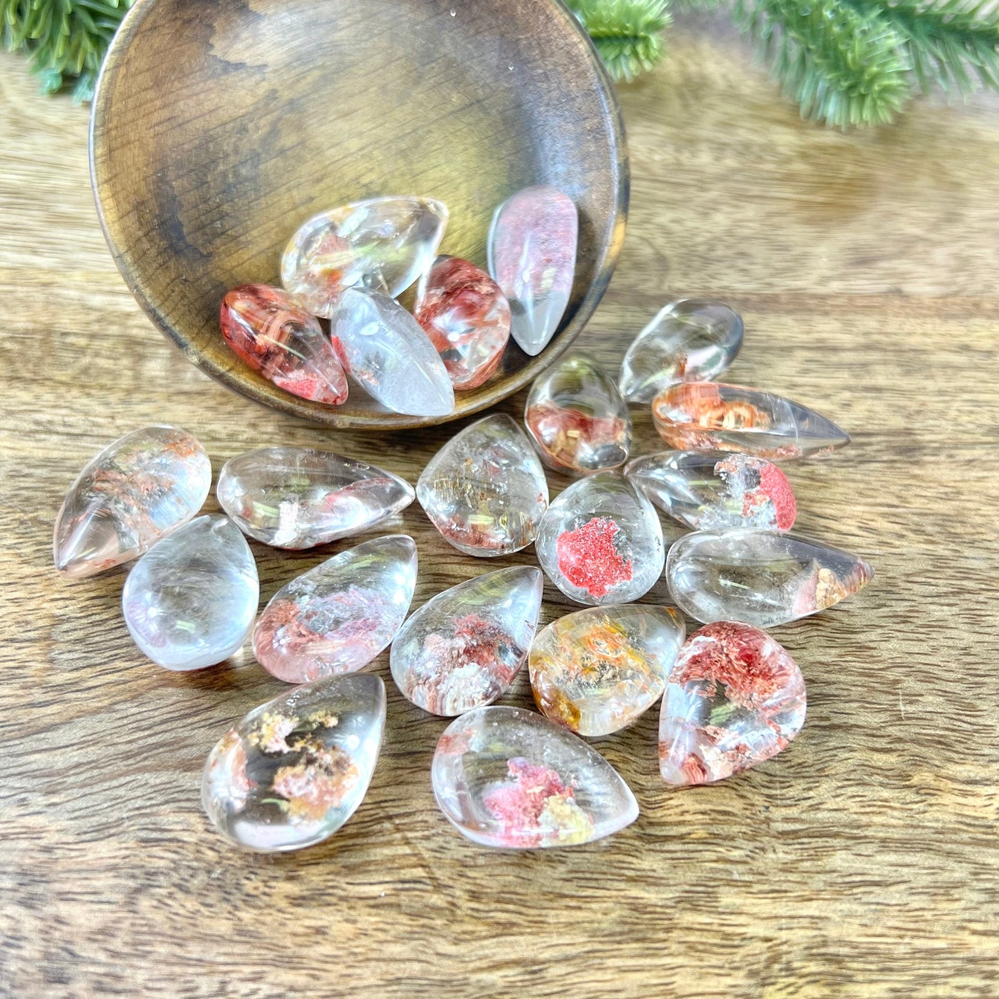 a group of lodolite Garden Quartz with dyed red inclusions in a wooden bowl