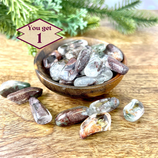 a wooden bowl filled with lodolite Garden Quartz tumbled crystals