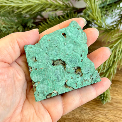 Cut slab of Malachite. Unpolished with a frosted finish. The back is natural and raw.