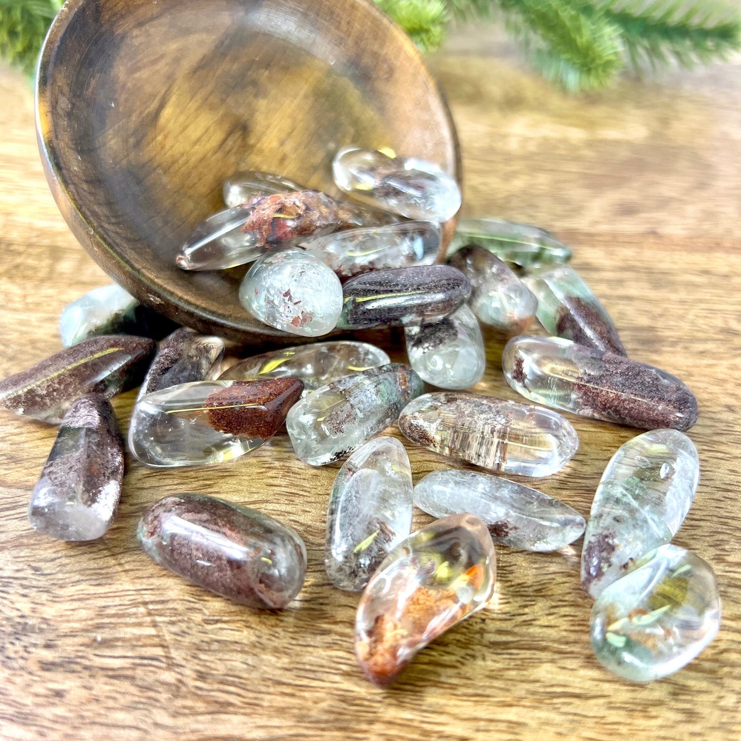 a wooden bowl filled with lodolite Garden Quartz tumbled crystals