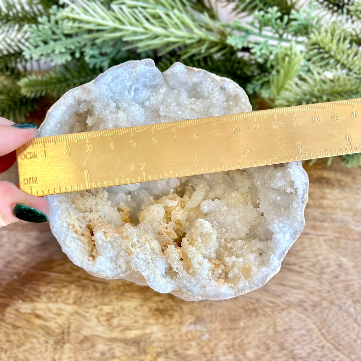 Image of a large Quartz sugar geode from Morocco. Has a sandy beige exterior, and lots of small, white crystals on the inside. Has some pale yellow iron staining on some crystals