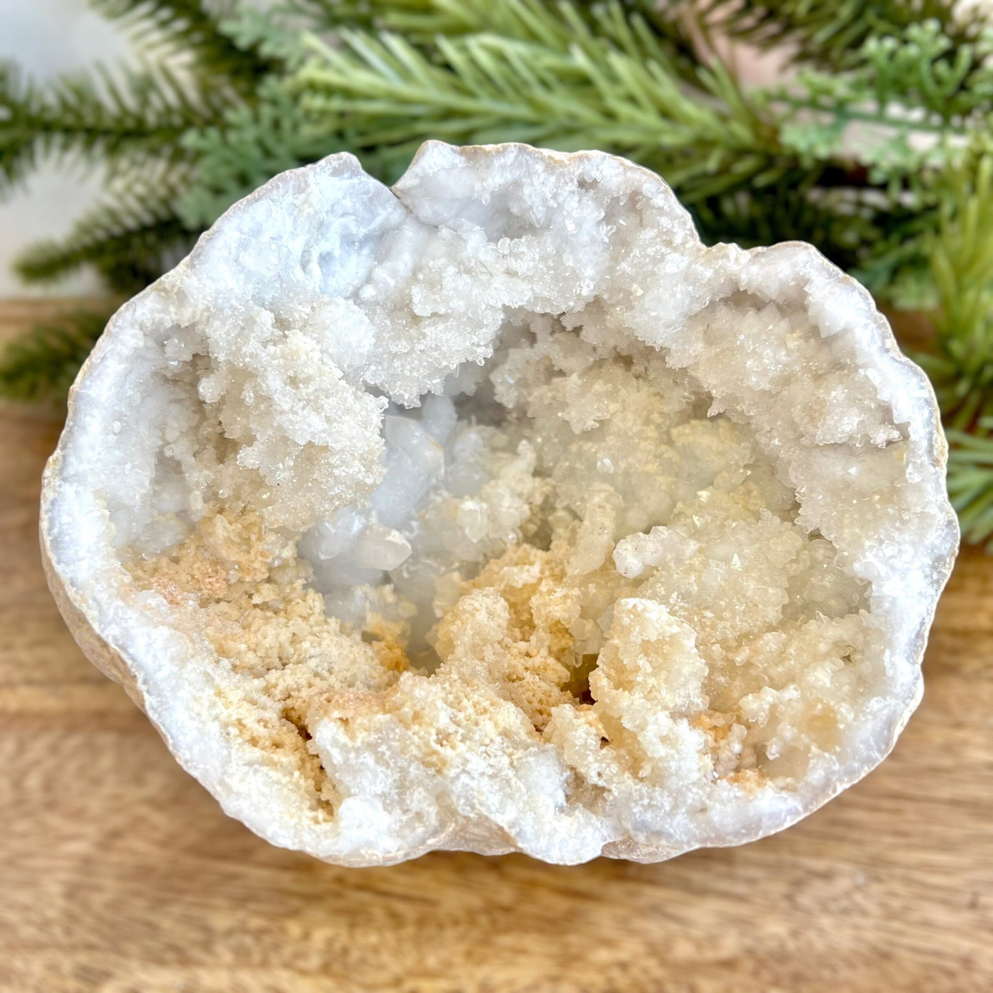 Image of a large Quartz sugar geode from Morocco. Has a sandy beige exterior, and lots of small, white crystals on the inside. Has some pale yellow iron staining on some crystals