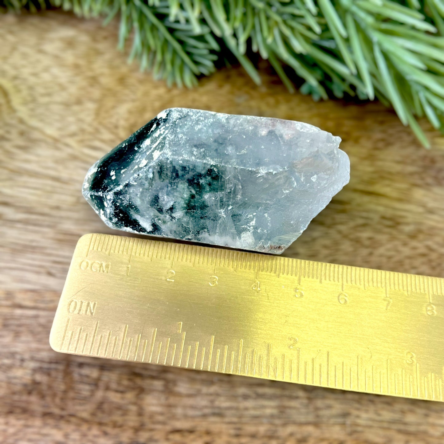 Close up of a small garden Quartz crystal point with chlorite inclusions. This mineral specimen is also called Lodolite, and is natural.