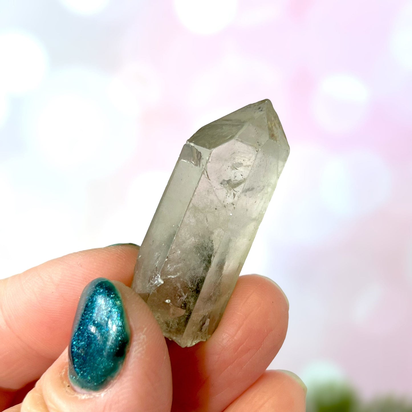 Close up of a small garden Quartz crystal point with chlorite inclusions. This mineral specimen is also called Lodolite, and is natural.