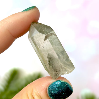 Close up of a small garden Quartz crystal point with chlorite inclusions. This mineral specimen is also called Lodolite, and is natural.