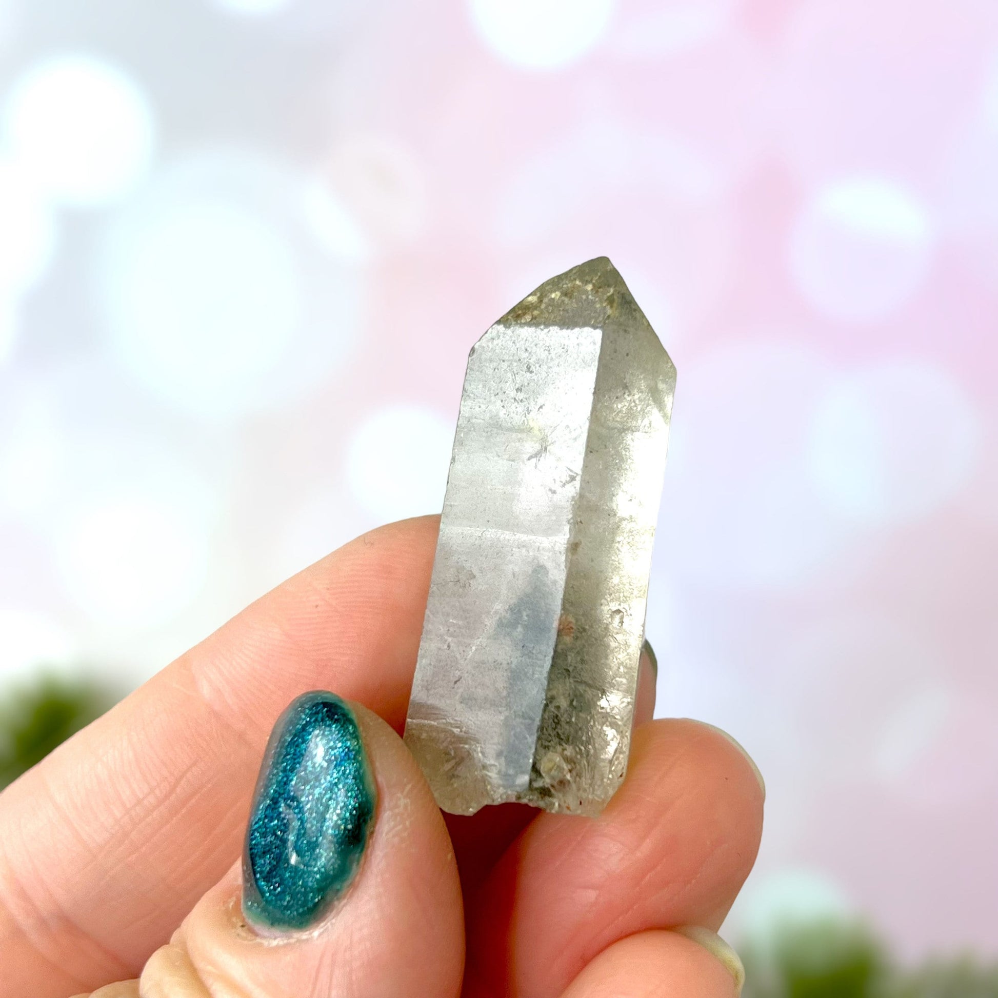 Close up of a small garden Quartz crystal point with chlorite inclusions. This mineral specimen is also called Lodolite, and is natural.