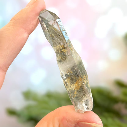 Close up of a small garden Quartz crystal point with chlorite inclusions. This mineral specimen is also called Lodolite, and is natural.