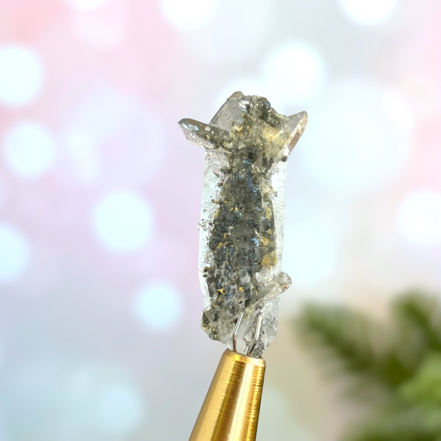 Close up of a small garden Quartz crystal point with chlorite inclusions. This mineral specimen is also called Lodolite, and is natural.