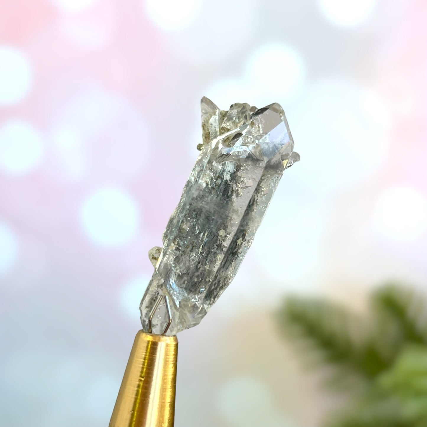 Close up of a small garden Quartz crystal point with chlorite inclusions. This mineral specimen is also called Lodolite, and is natural.