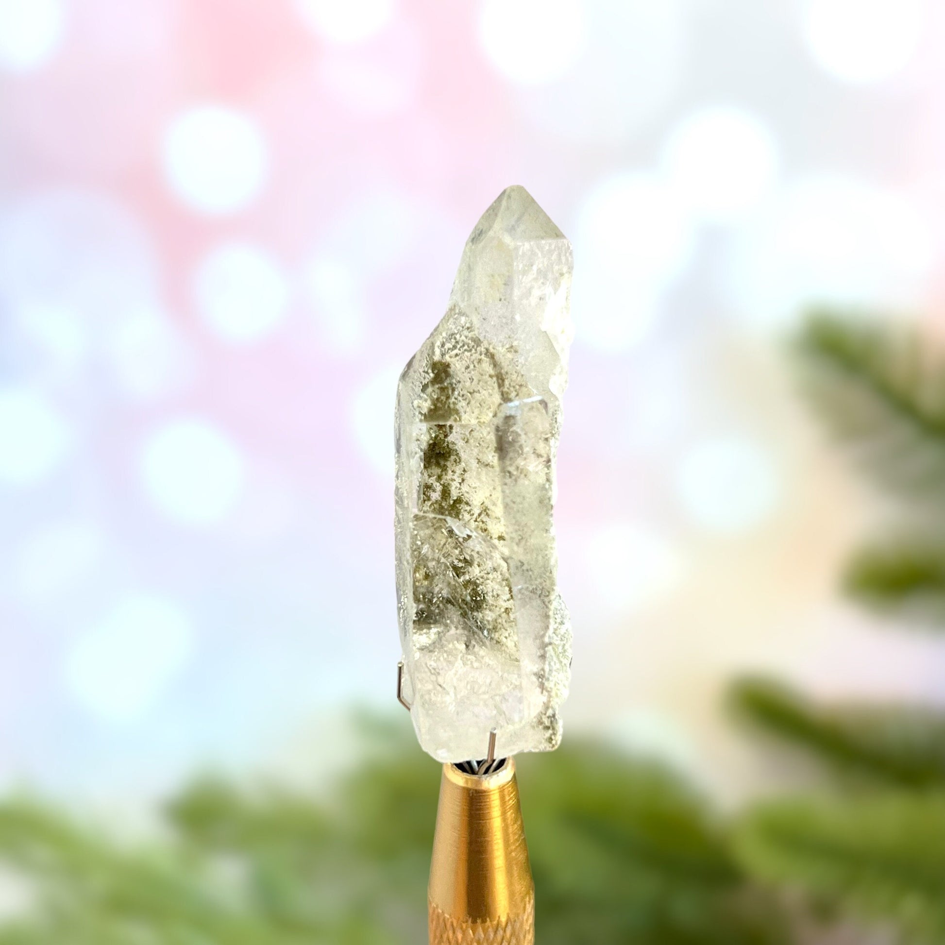 Close up of a small garden Quartz crystal point with chlorite inclusions. This mineral specimen is also called Lodolite, and is natural.