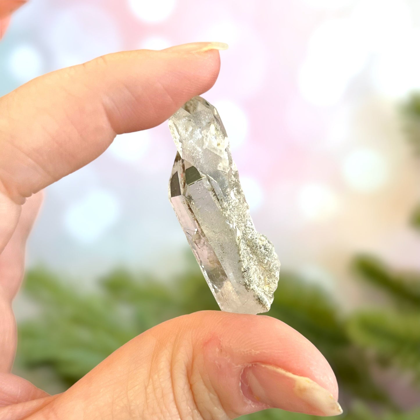 Close up of a small garden Quartz crystal point with chlorite inclusions. This mineral specimen is also called Lodolite, and is natural.