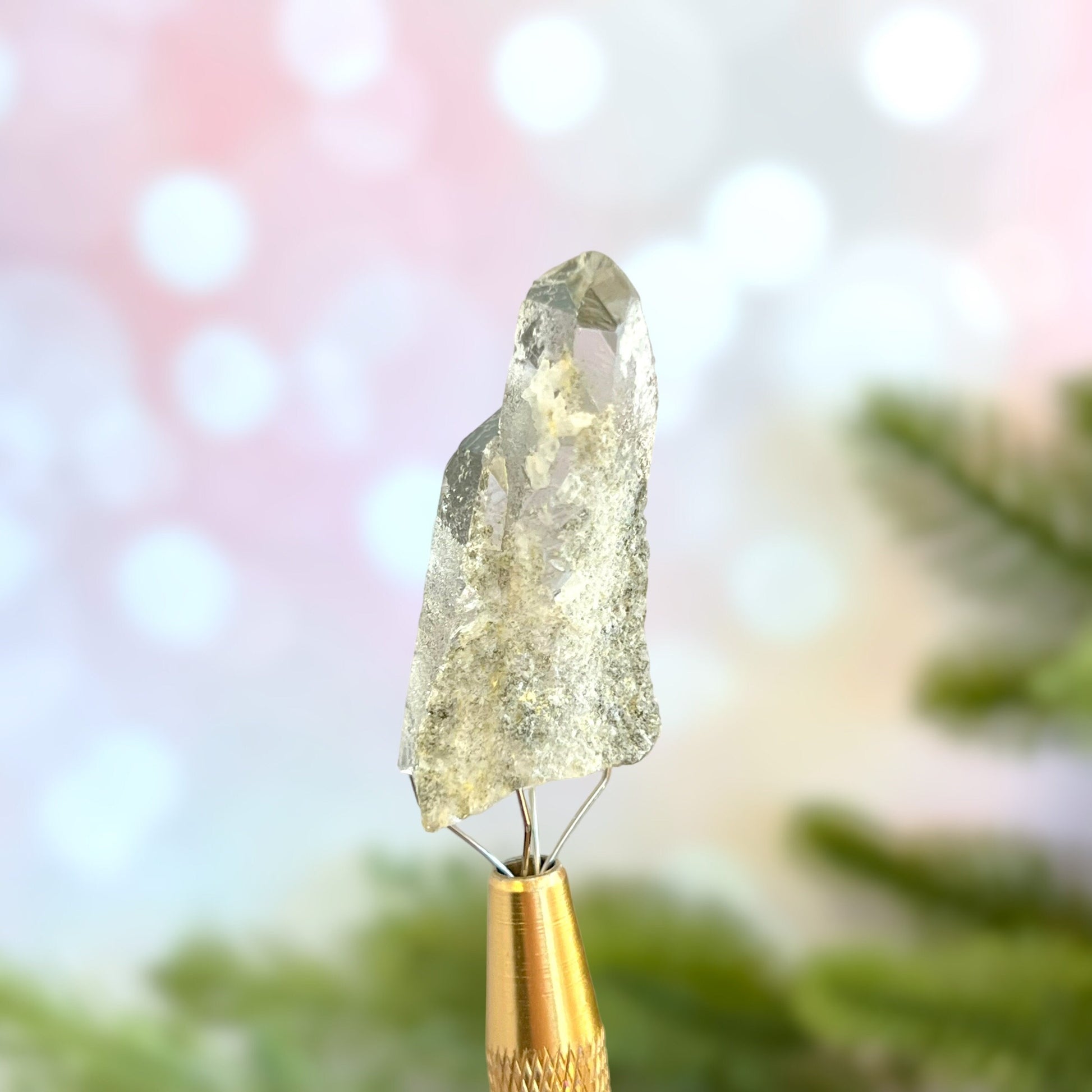 Close up of a small garden Quartz crystal point with chlorite inclusions. This mineral specimen is also called Lodolite, and is natural.