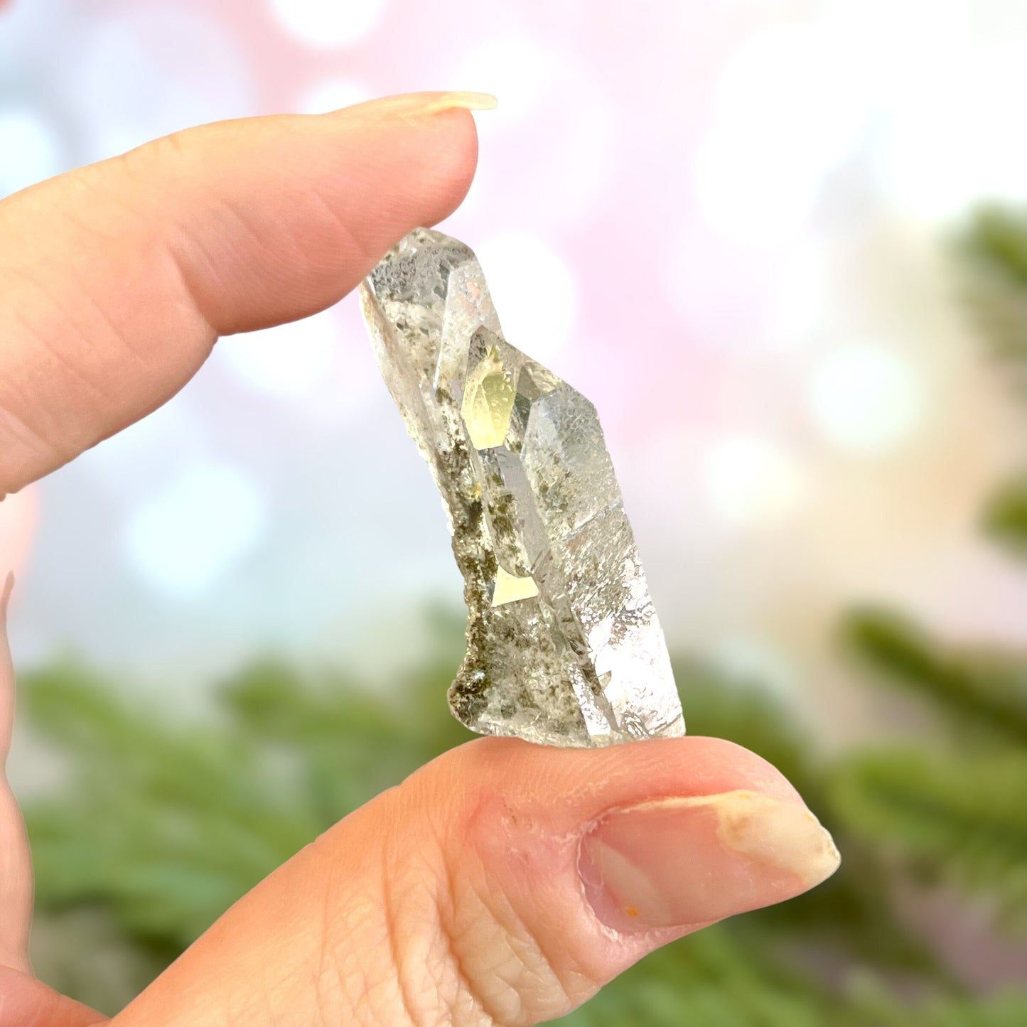 Close up of a small garden Quartz crystal point with chlorite inclusions. This mineral specimen is also called Lodolite, and is natural.