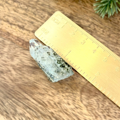 Close up of a small garden Quartz crystal point with chlorite inclusions. This mineral specimen is also called Lodolite, and is natural.