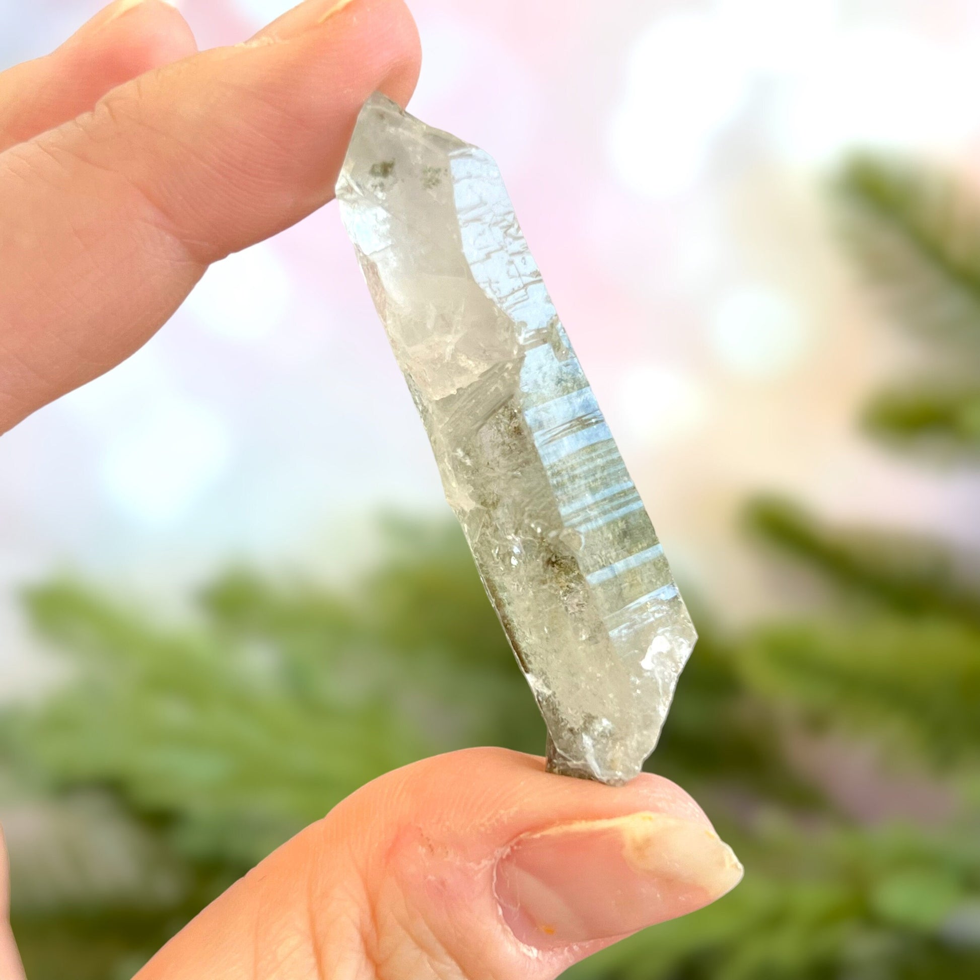 Close up of a small garden Quartz crystal point with chlorite inclusions. This mineral specimen is also called Lodolite, and is natural.