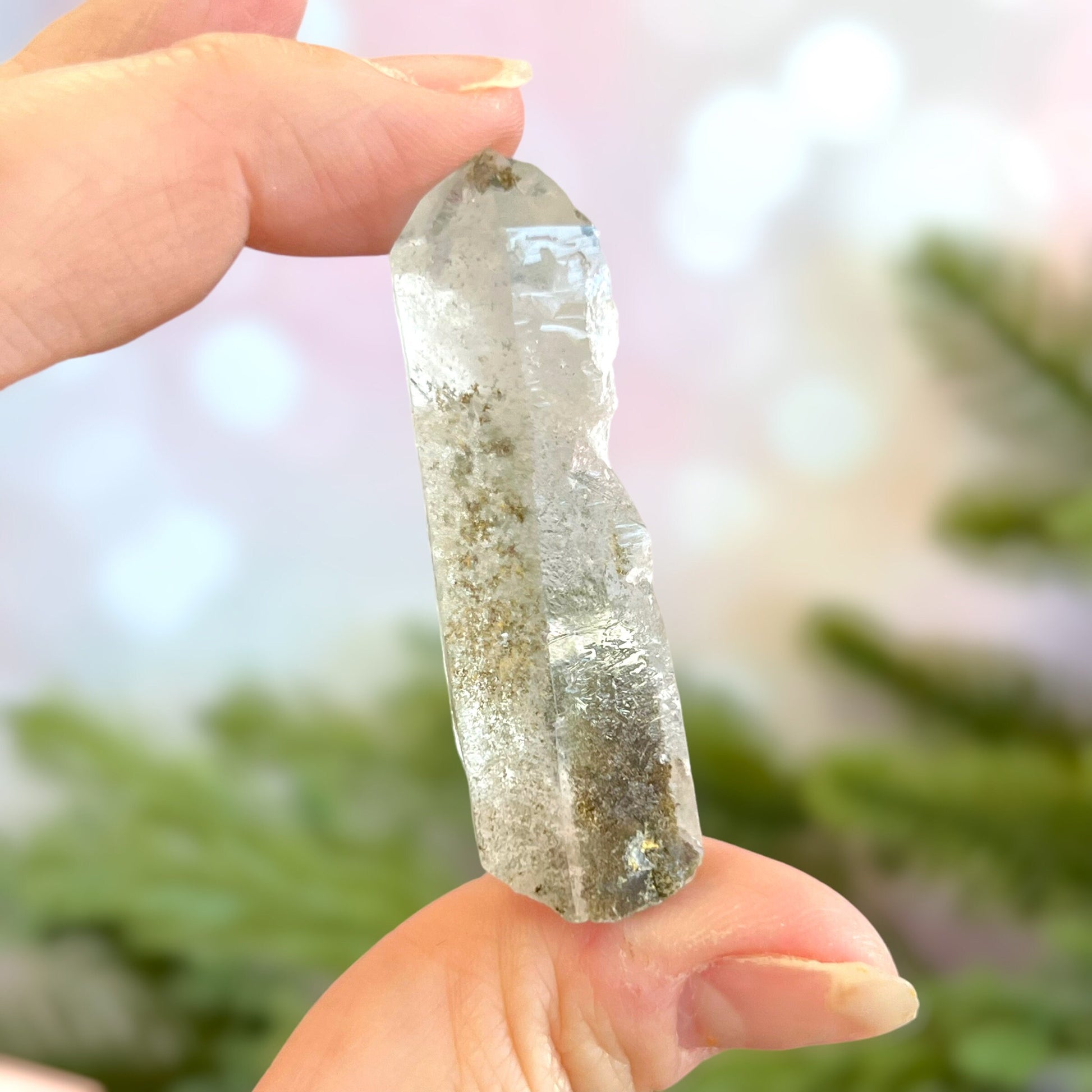 Close up of a small garden Quartz crystal point with chlorite inclusions. This mineral specimen is also called Lodolite, and is natural.