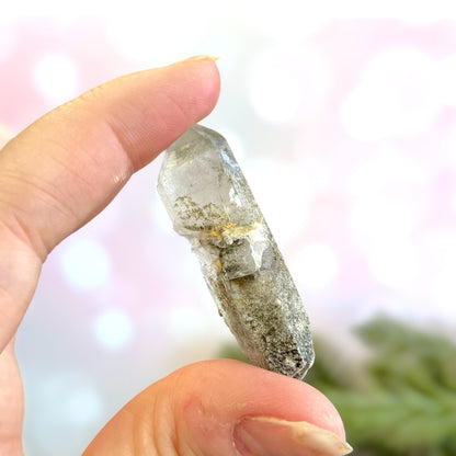 Close up of a small garden Quartz crystal point with chlorite inclusions. This mineral specimen is also called Lodolite, and is natural.