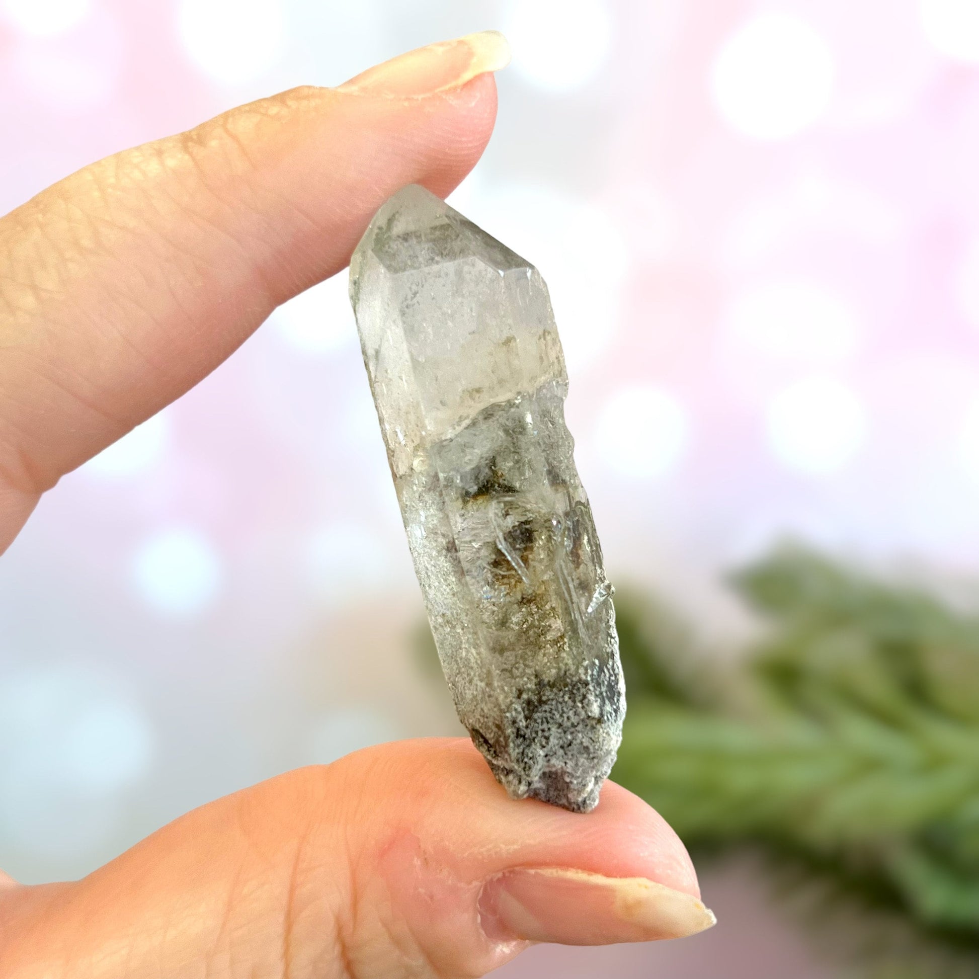 Close up of a small garden Quartz crystal point with chlorite inclusions. This mineral specimen is also called Lodolite, and is natural.