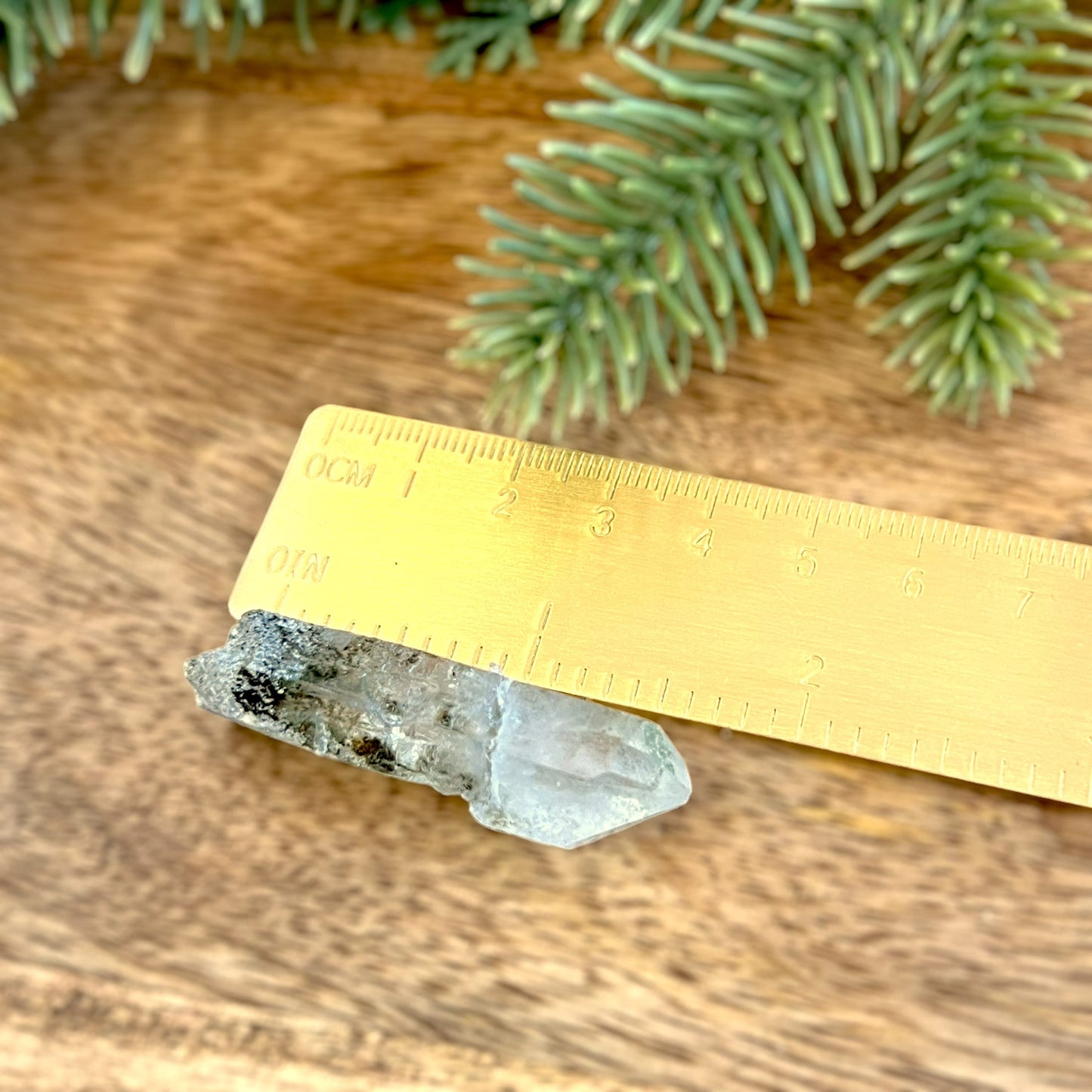 Close up of a small garden Quartz crystal point with chlorite inclusions. This mineral specimen is also called Lodolite, and is natural.