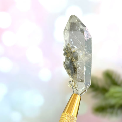 Close up of a small garden Quartz crystal point with chlorite inclusions. This mineral specimen is also called Lodolite, and is natural.