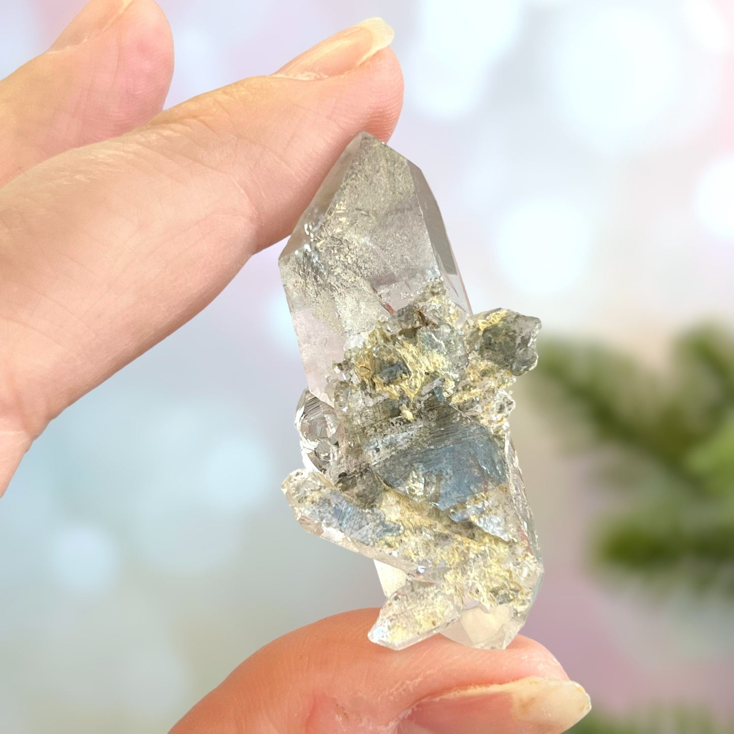 Close up of a small garden Quartz crystal point with chlorite inclusions. This mineral specimen is also called Lodolite, and is natural.