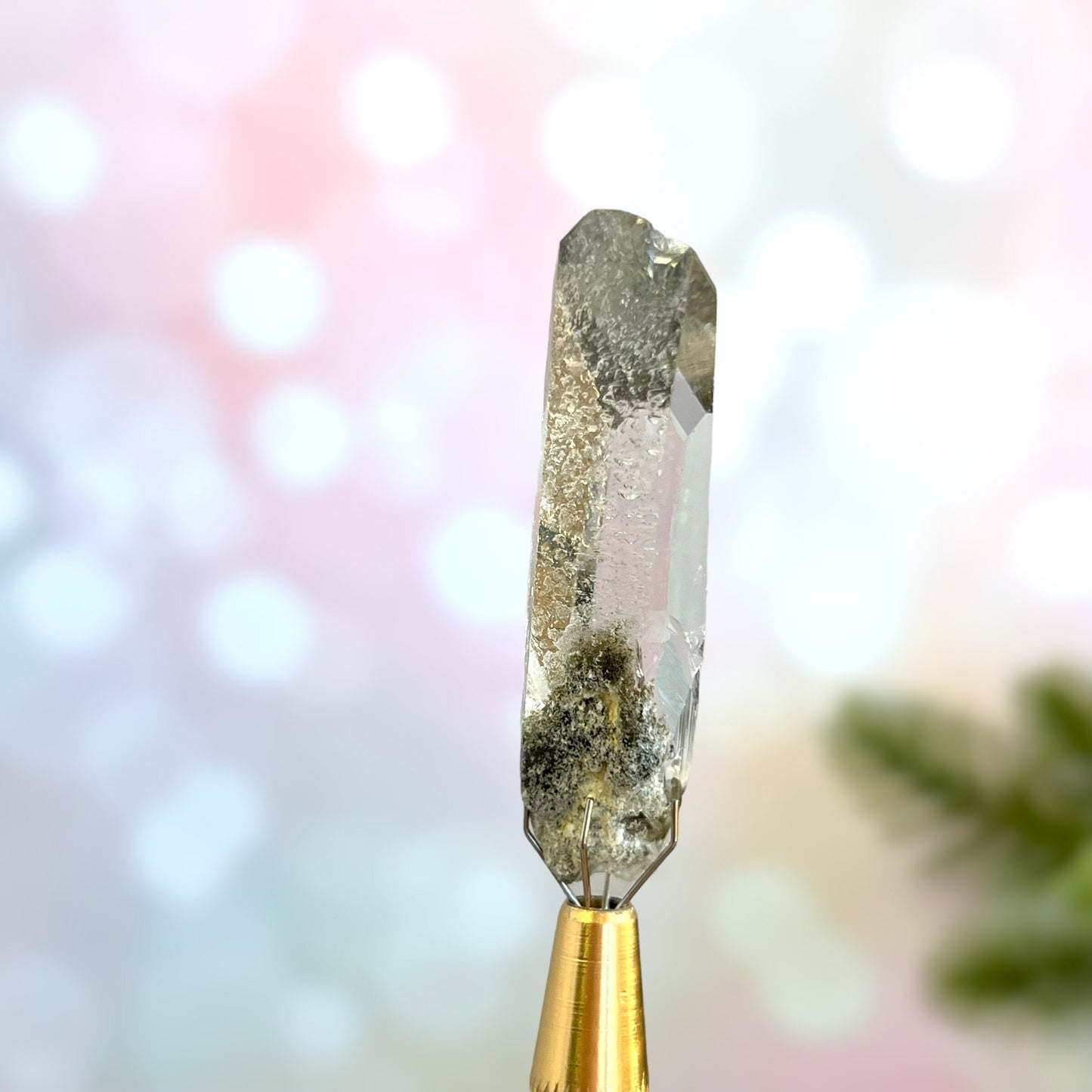 Close up of a small garden Quartz crystal point with chlorite inclusions. This mineral specimen is also called Lodolite, and is natural.