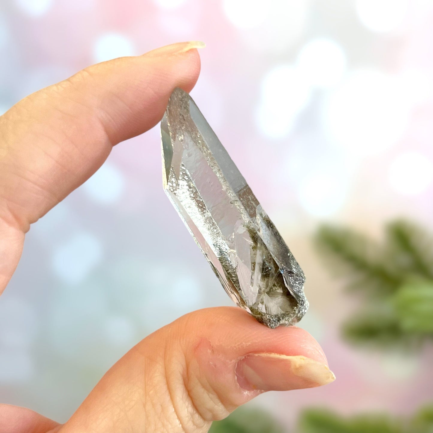 Close up of a small garden Quartz crystal point with chlorite inclusions. This mineral specimen is also called Lodolite, and is natural.