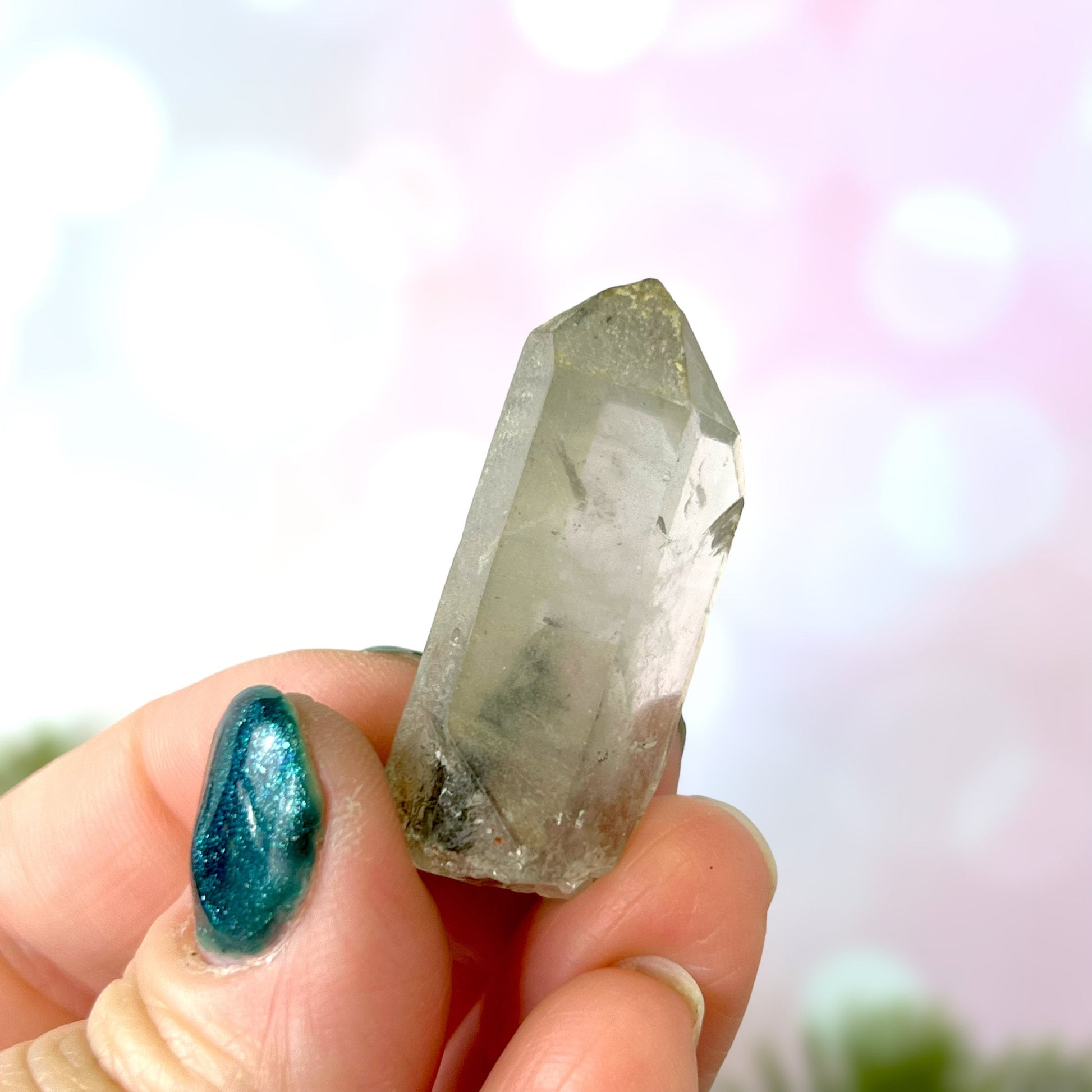 Close up of a small garden Quartz crystal point with chlorite inclusions. This mineral specimen is also called Lodolite, and is natural.