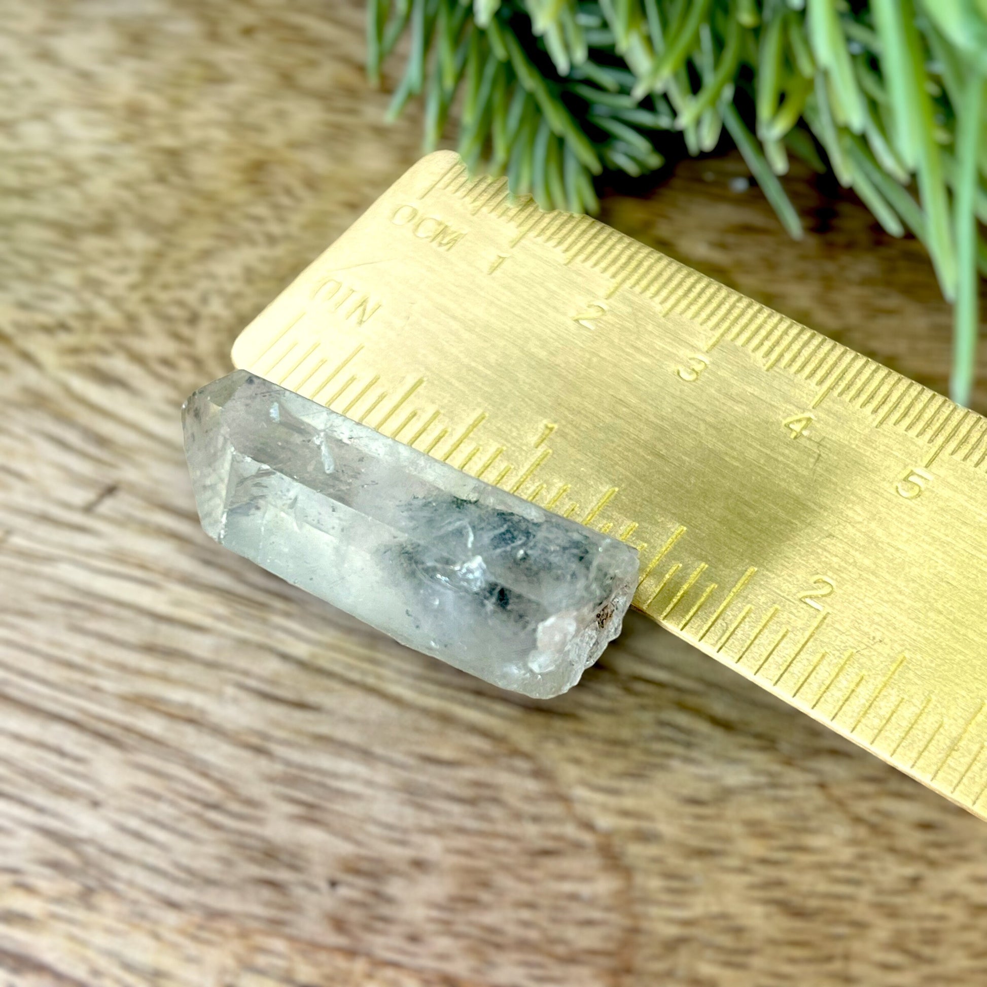 Close up of a small garden Quartz crystal point with chlorite inclusions. This mineral specimen is also called Lodolite, and is natural.