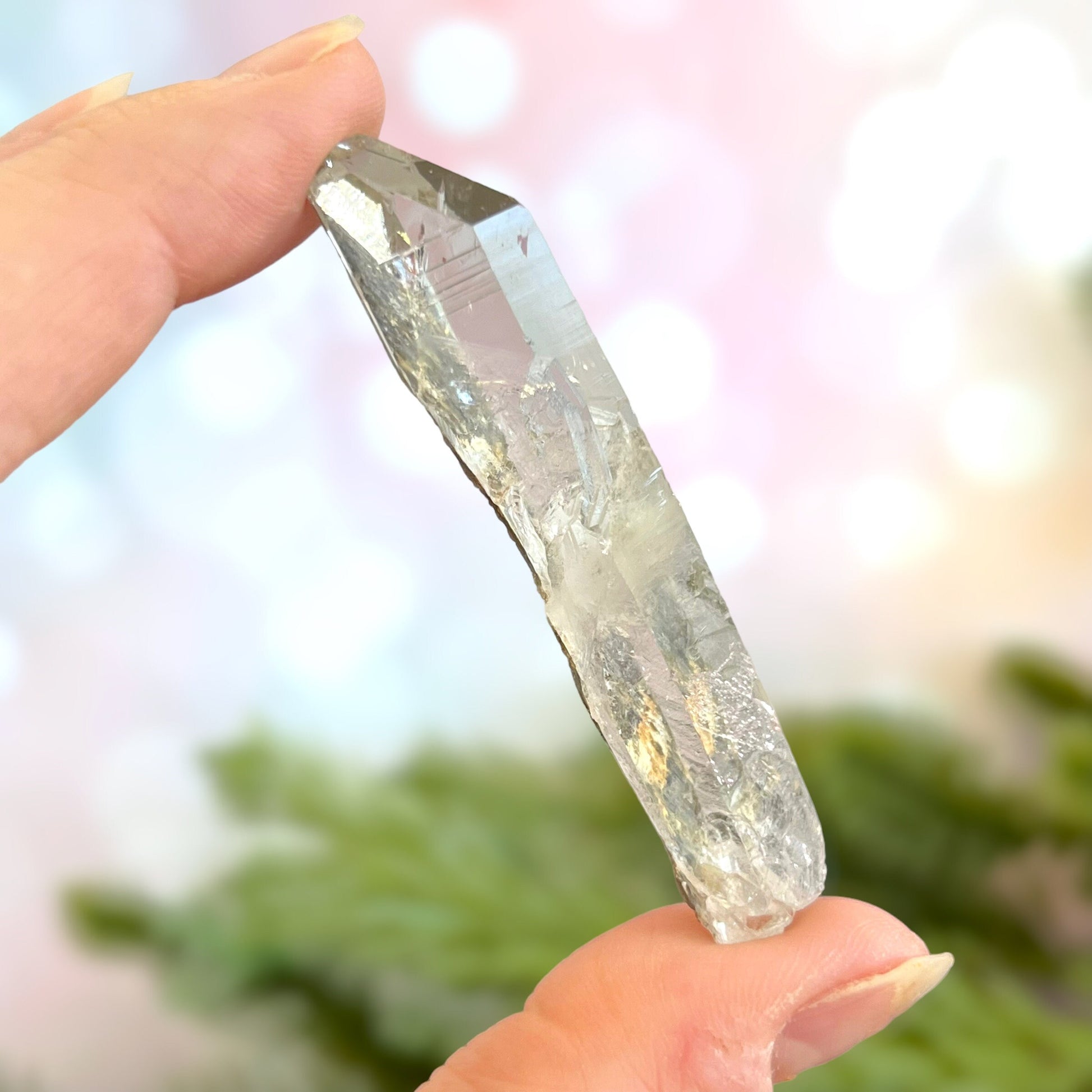 Close up of a small garden Quartz crystal point with chlorite inclusions. This mineral specimen is also called Lodolite, and is natural.