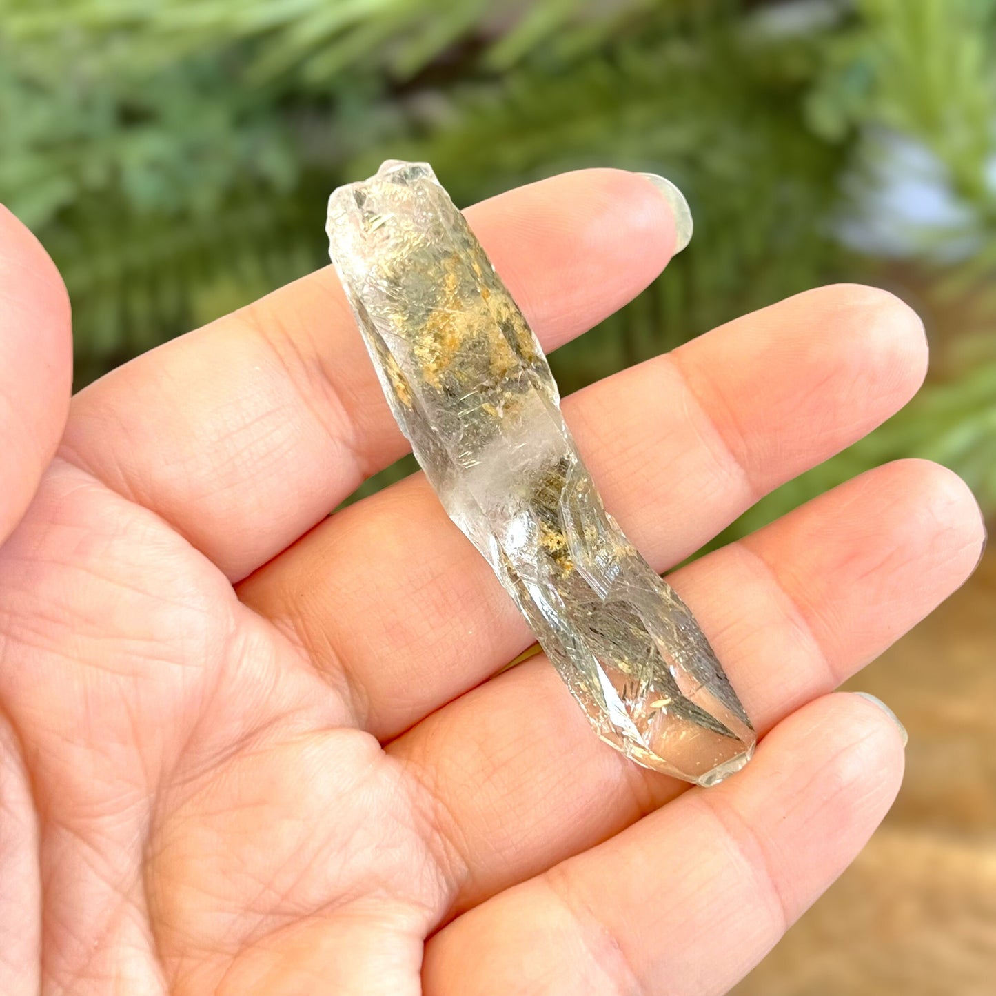 Close up of a small garden Quartz crystal point with chlorite inclusions. This mineral specimen is also called Lodolite, and is natural.