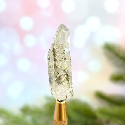 Close up of a small garden Quartz crystal point with chlorite inclusions. This mineral specimen is also called Lodolite, and is natural.