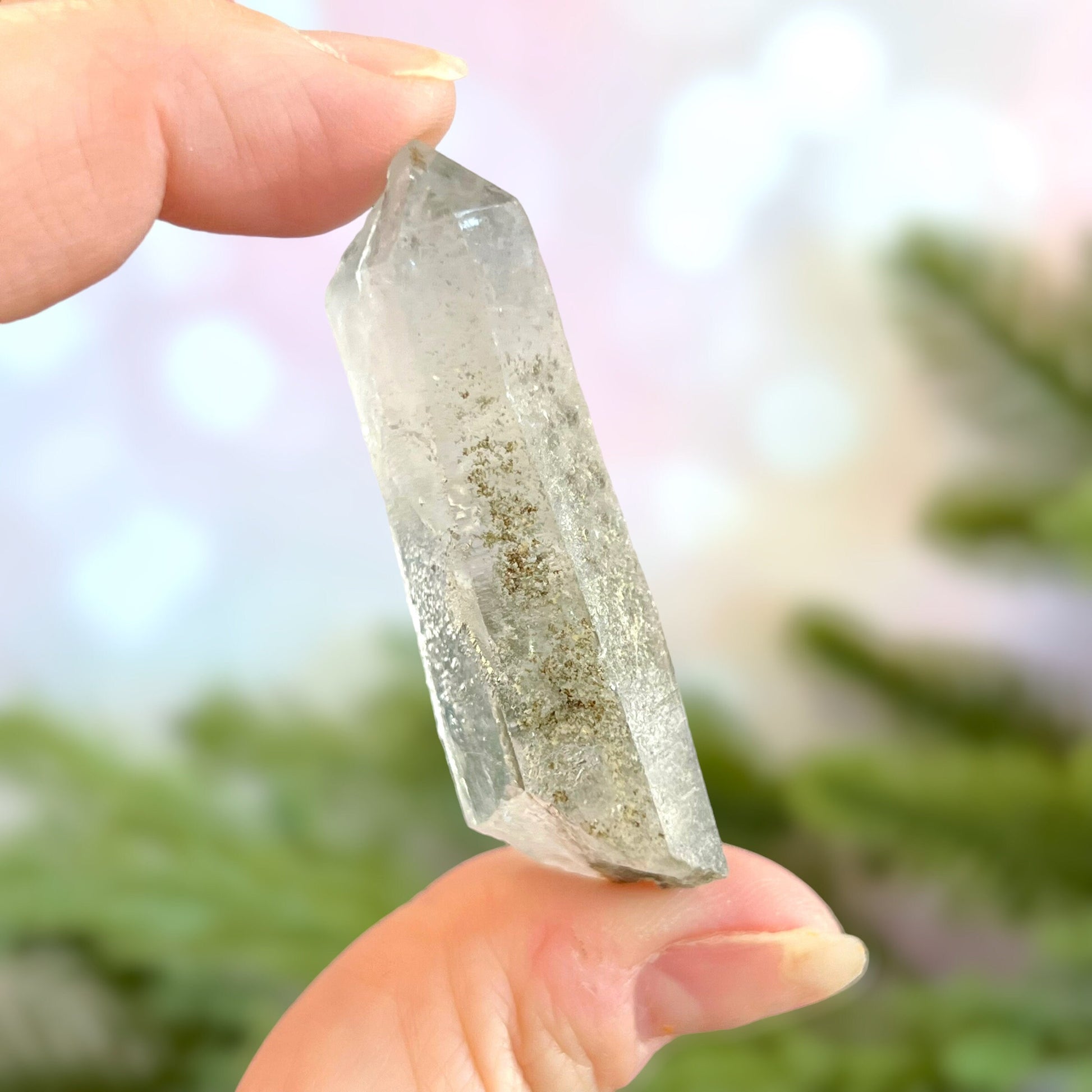 Close up of a small garden Quartz crystal point with chlorite inclusions. This mineral specimen is also called Lodolite, and is natural.