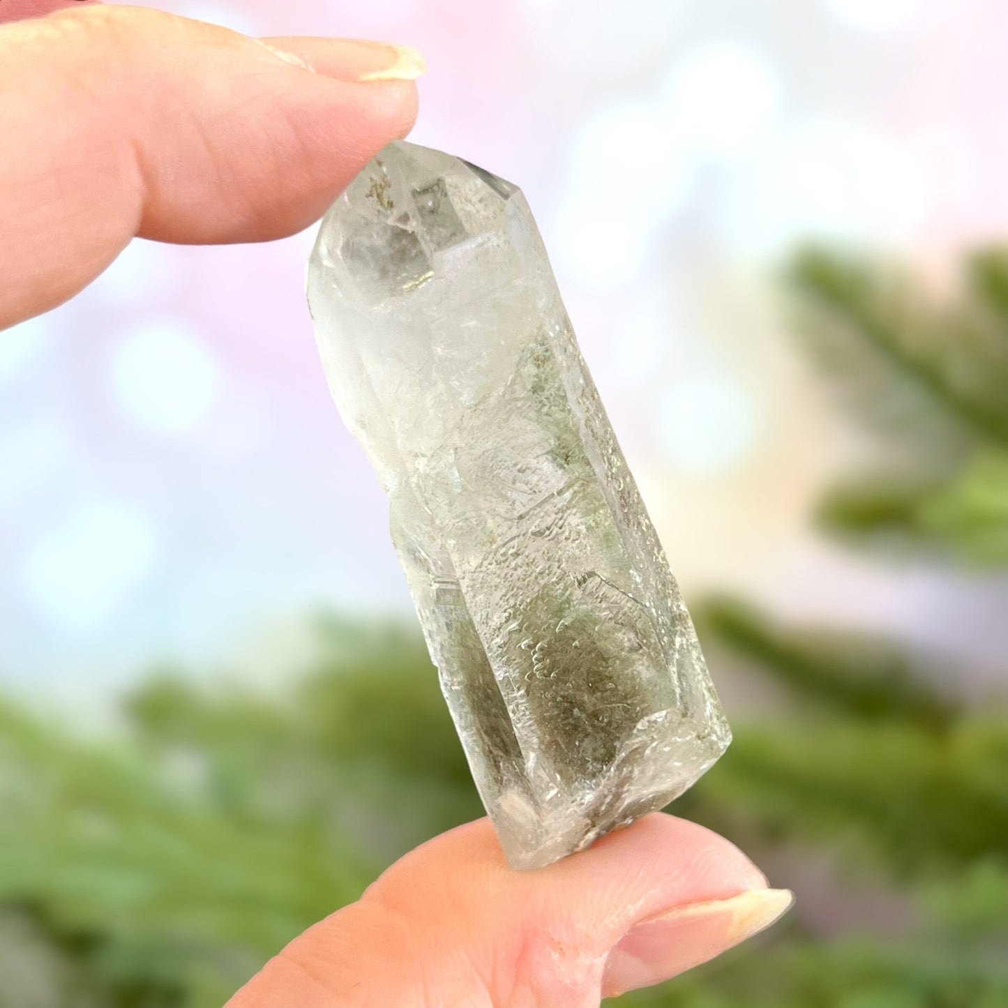 Close up of a small garden Quartz crystal point with chlorite inclusions. This mineral specimen is also called Lodolite, and is natural.