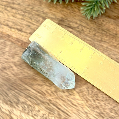 Close up of a small garden Quartz crystal point with chlorite inclusions. This mineral specimen is also called Lodolite, and is natural.