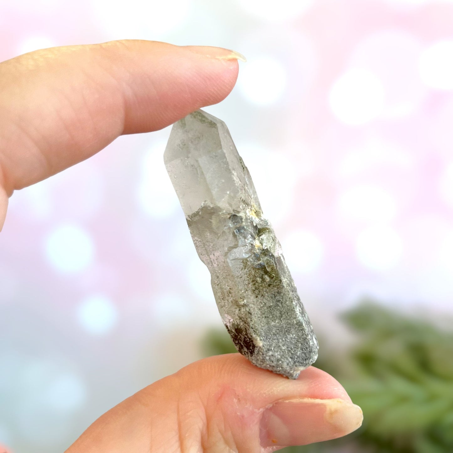 Close up of a small garden Quartz crystal point with chlorite inclusions. This mineral specimen is also called Lodolite, and is natural.