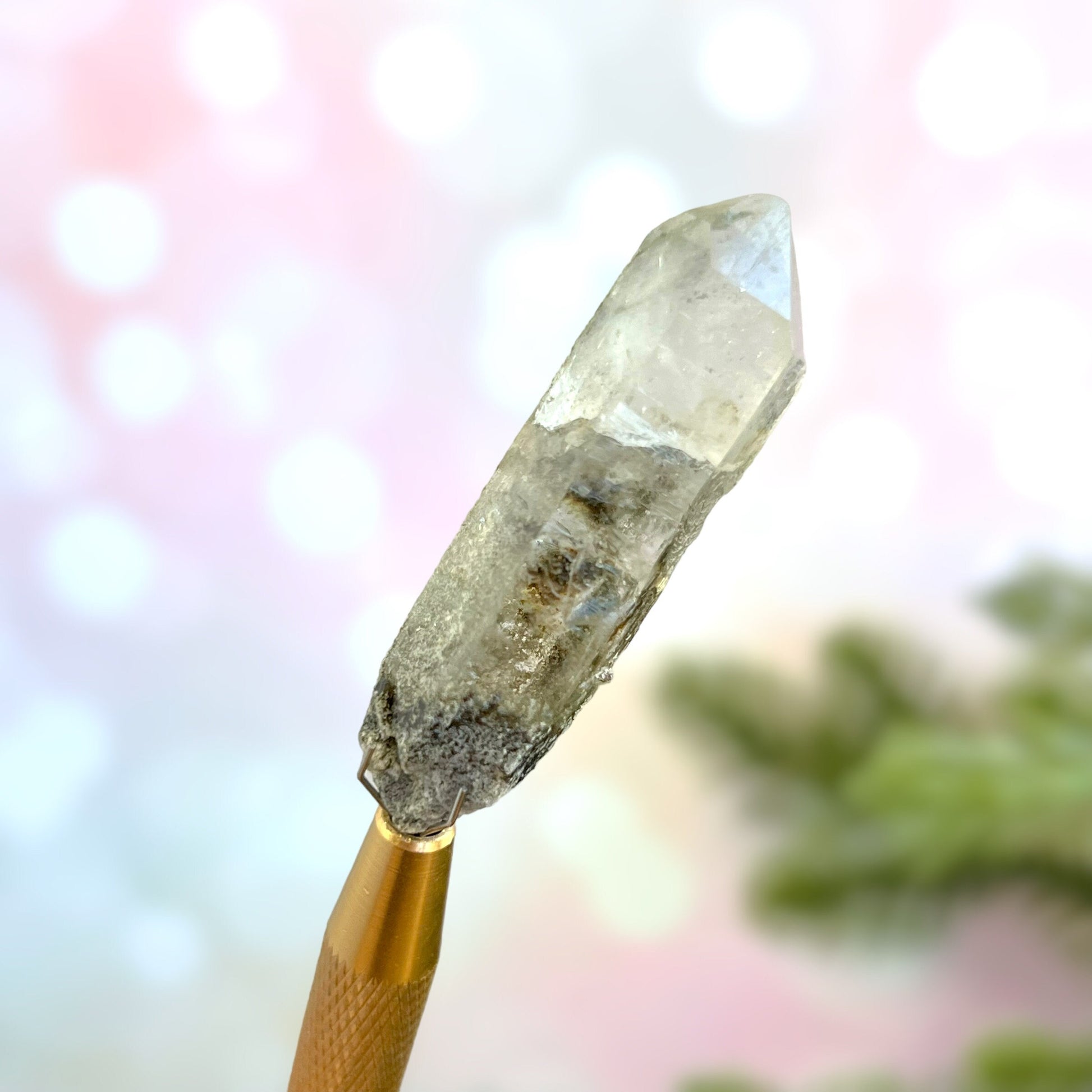 Close up of a small garden Quartz crystal point with chlorite inclusions. This mineral specimen is also called Lodolite, and is natural.