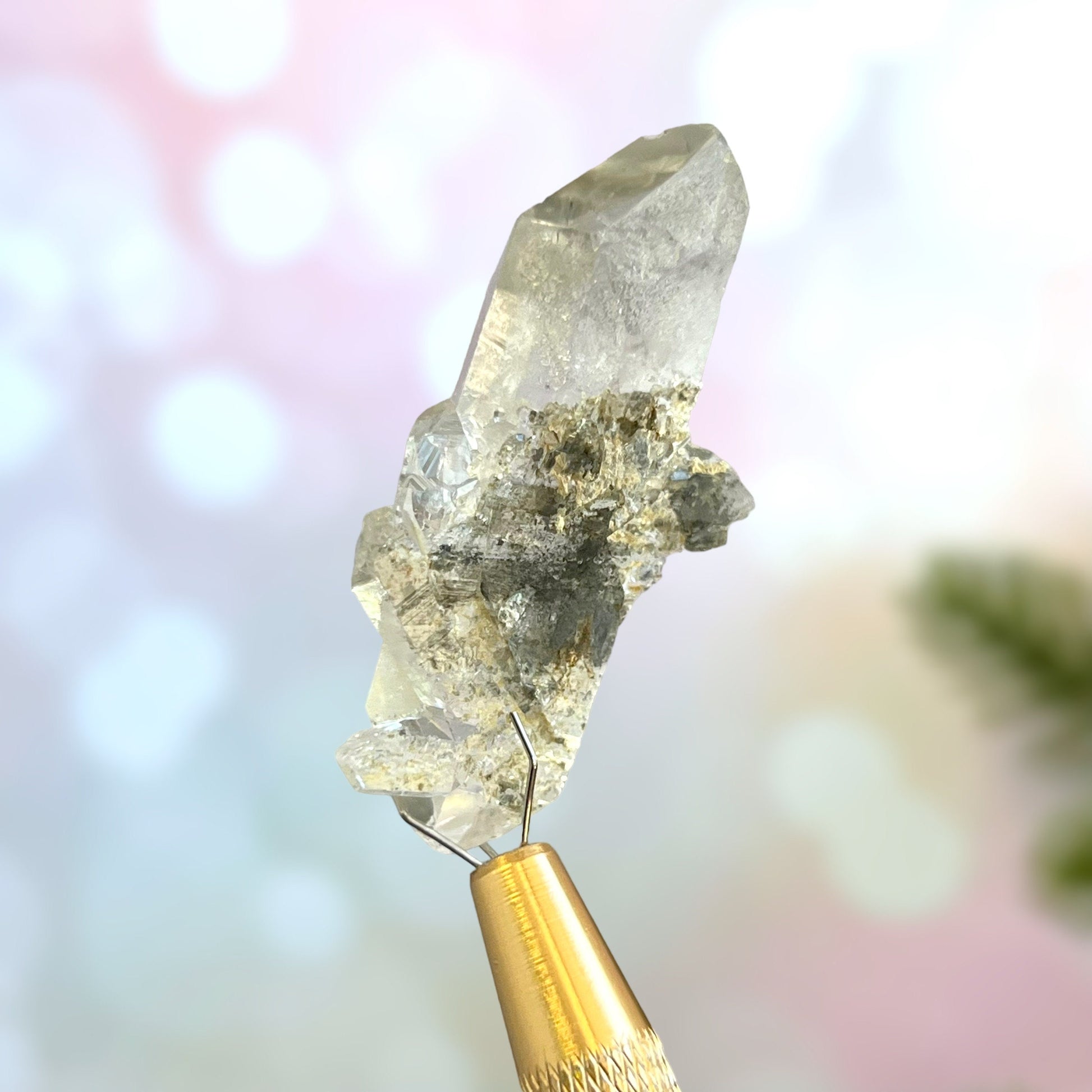 Close up of a small garden Quartz crystal point with chlorite inclusions. This mineral specimen is also called Lodolite, and is natural.