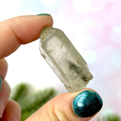 Close up of a small garden Quartz crystal point with chlorite inclusions. This mineral specimen is also called Lodolite, and is natural.