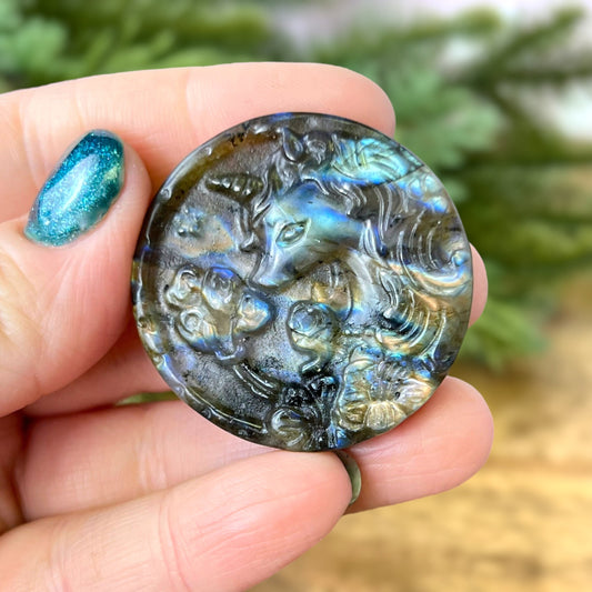 Labradorite Crystal cabochon carved into a circle. Features a unicorn head looking at a butterfly